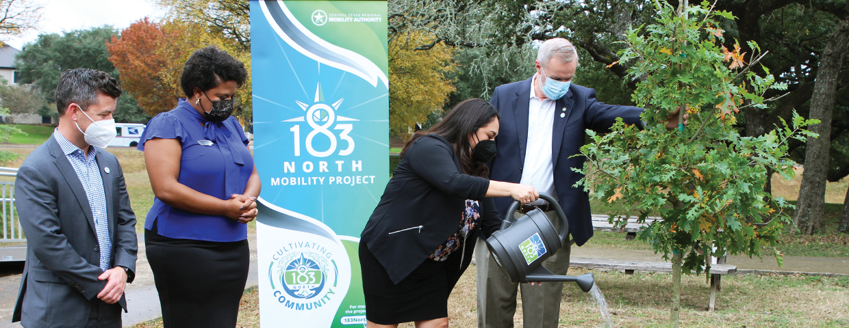 James M. Bass, Executive Director of the Central Texas Regional Mobility Authority, and Principal Amanda Serna-Castro water a tree while members of RRISD look on at Grisham Middle School.
