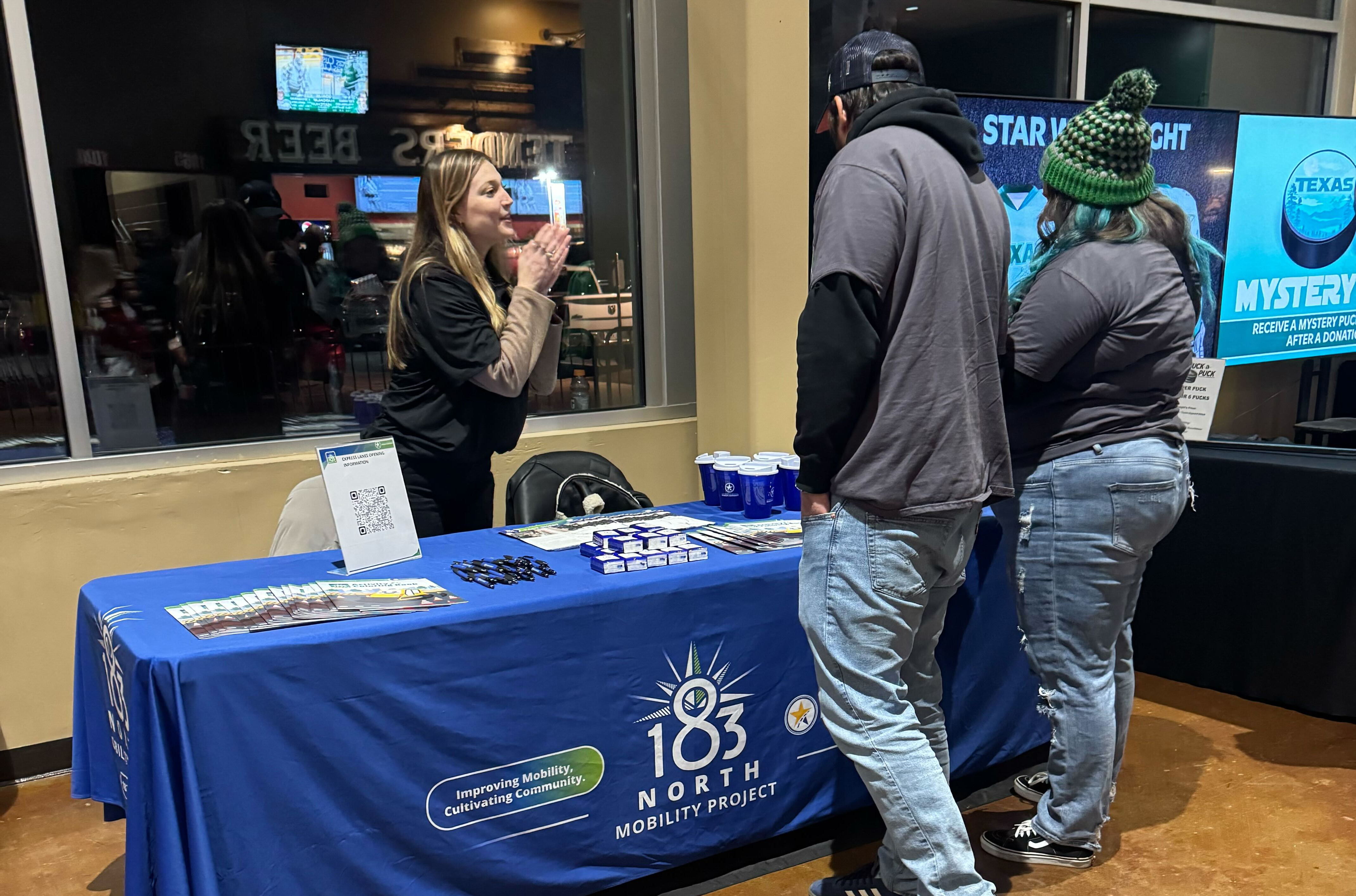 The 183 North Mobility Project team talks with attendees at a Texas Stars game.