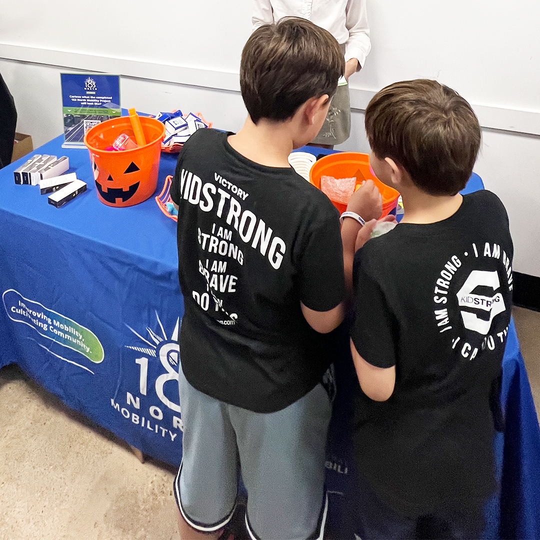 Two children gathered at info table