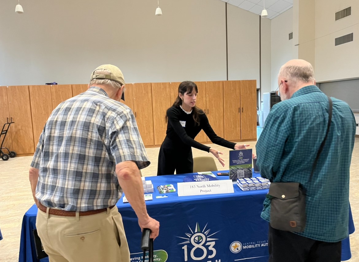 Representative greeting attendees at an informational table