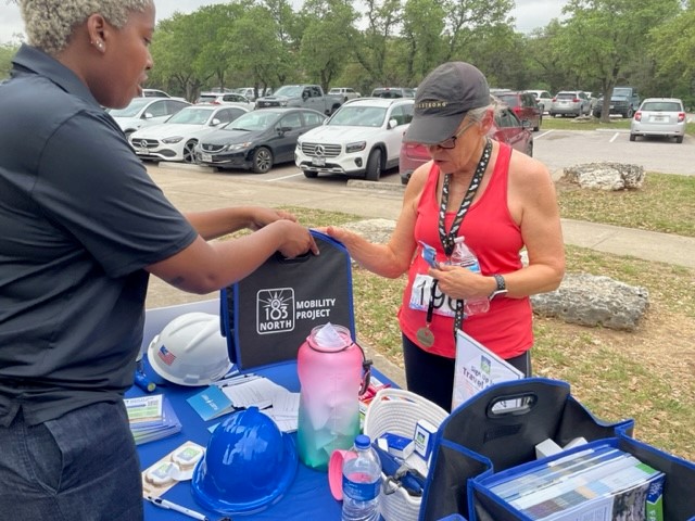 Woman runner speaks to woman at informational booth